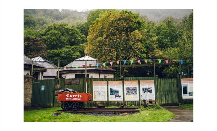 An old slate truck and information boards outside of Corris Mine Explorers based at Corris Caverns in Mid Wales